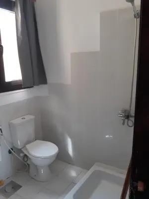 a white bathroom with a toilet and a bath tub at Апартаменты в Хургаде, Stella Makadi in Hurghada