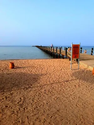 a beach with a pier and a sign on it at Апартаменты в Хургаде, Stella Makadi in Hurghada