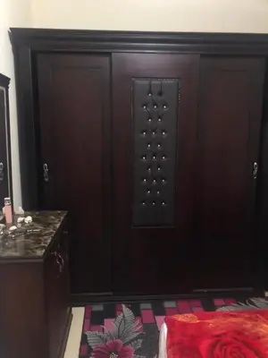 a wooden door in a room with a bed at Red Sea Tiba plaza Apartment in Hurghada