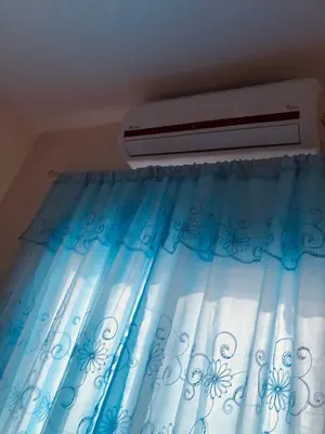 a bedroom with a window with a air conditioner at Red Sea Tiba plaza Apartment in Hurghada