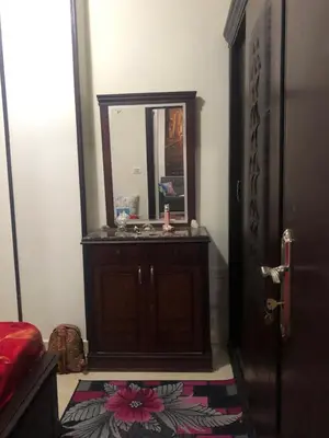 a bathroom with a wooden vanity with a mirror at Red Sea Tiba plaza Apartment in Hurghada