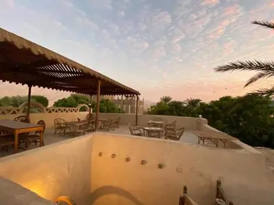 a patio with tables and chairs and a roof at Nour El Balad in Luxor