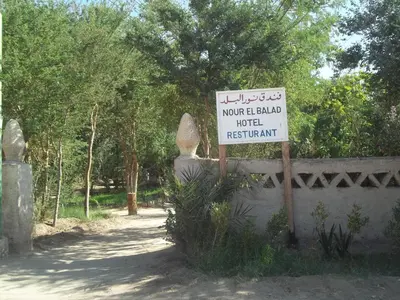 a sign on a wall next to a road with a sign at Nour El Balad in Luxor