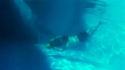 a person swimming in a pool of water at Luxury Seafront Pool Villa - 3 Stories & Roof floor - All Master Bedrooms in Hurghada