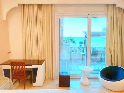 a living room with a desk and a large window at Luxury Seafront Pool Villa - 3 Stories & Roof floor - All Master Bedrooms in Hurghada