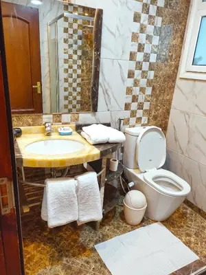 a bathroom with a sink and a toilet and a mirror at Luxury Seafront Pool Villa - 3 Stories & Roof floor - All Master Bedrooms in Hurghada