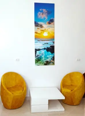 two chairs and a table in a room with a painting at Luxury Seafront Pool Villa - 3 Stories & Roof floor - All Master Bedrooms in Hurghada