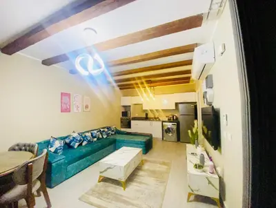 a living room with a green couch and a table at LuxVilla 1 BHK W Private Heated Pool in Bali El Gouna in Hurghada