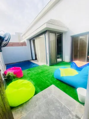 a backyard with artificial grass and a house at LuxVilla 1 BHK W Private Heated Pool in Bali El Gouna in Hurghada