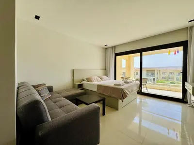 a bedroom with a bed and a couch and a bed at Cozy Studio Apt @ G-cribs El Gouna with a View. in Hurghada