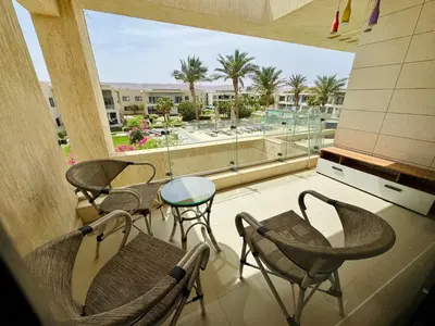 a balcony with chairs and a table and a view at Cozy Studio Apt @ G-cribs El Gouna with a View. in Hurghada