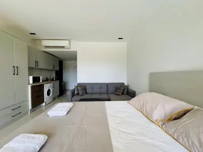 a living room with a large bed and a couch at Cozy Studio Apt @ G-cribs El Gouna with a View. in Hurghada
