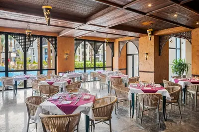 a dining room with tables and chairs and windows at Pickalbatros Sands Port Ghalib in Port Ghalib