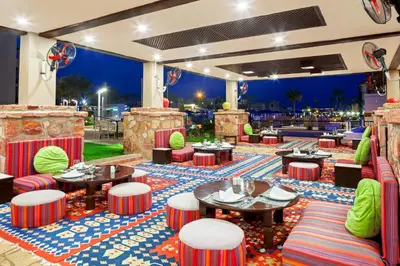 a restaurant with tables and chairs and a bar at Pickalbatros Sands Port Ghalib in Port Ghalib
