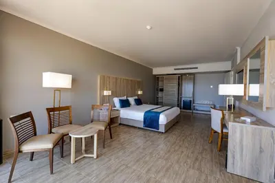 a hotel room with a bed and chairs and a table at Seven Seas Jolie Bay - Ultra All Inclusive in Hurghada