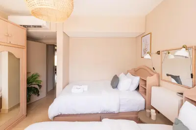 a bedroom with a large white bed in a room at Dashing 2 BDR Mangroovy Free Pool & Beach Access in Hurghada