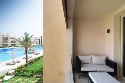 a balcony with a couch and a view of a pool at Dashing 2 BDR Mangroovy Free Pool & Beach Access in Hurghada