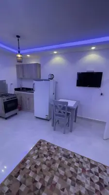 a kitchen with a table and a refrigerator in it at Palma house apartments A8 in Hurghada
