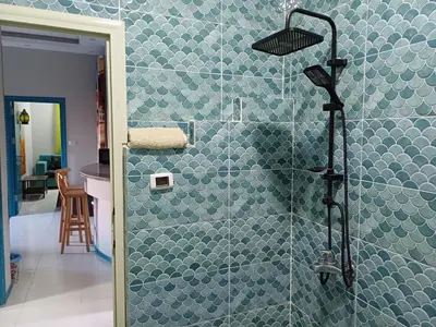 a bathroom with a shower with a blue tiled wall at Sun & Fun in Quseir