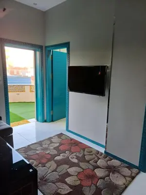 a room with a refrigerator and a door with a rug at Sun & Fun in Quseir