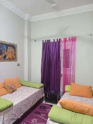 two beds in a room with purple curtains at Sun & Fun in Quseir
