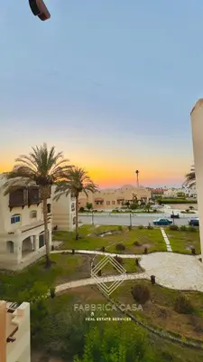 a view of a park with palm trees and a building at Beautiful 1 bedroom apartment in Quseir