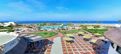 a view of a resort with a pool and people with umbrellas at Bliss Nada Beach Resort in Coraya Bay