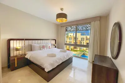 a bedroom with a large bed and a large window at Homestyle 3BR Penthouse Pool & Beach View in Hurghada