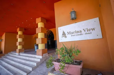 a sign on the side of a building with some plants at Marina view port ghalib in Port Ghalib