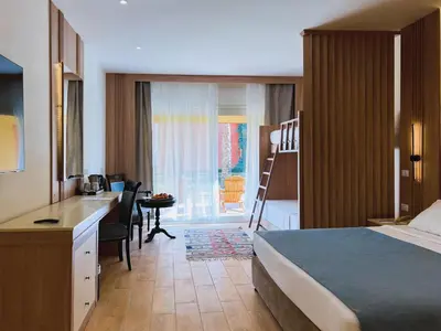 a hotel room with a bedroom with a bed and a desk at Sentido Caribbean World Soma Bay in Hurghada