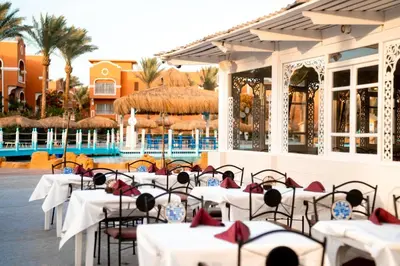 a restaurant with tables and chairs in front of a pool at Sentido Caribbean World Soma Bay in Hurghada