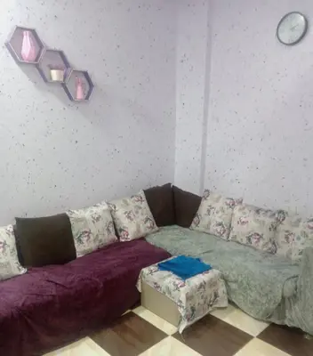 a living room with a couch and a clock on the wall at Yasin - Enjoy the privacy of staying in a quiet apartment with free Wi-Fi as your complete second home in the heart of Hurghada in Hurghada