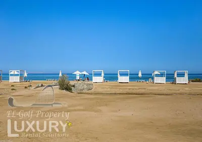 a beach with chairs and umbrellas on the beach at Mangarov-2BR. M1-6b-12 in Hurghada
