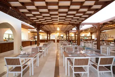 a restaurant with wooden ceilings and tables and chairs at Xanadu Makadi Bay - High Class All Inclusive in Hurghada
