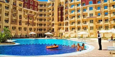 a man in a suit standing in a swimming pool next to a building at Florenza khamsin home Hurghada in Hurghada