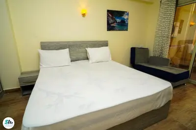 a bedroom with a large white bed and a chair at Florenza khamsin home Hurghada in Hurghada