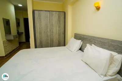 a bedroom with a bed with white sheets and pillows at Florenza khamsin home Hurghada in Hurghada