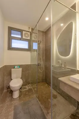 a bathroom with a toilet and a shower and a sink at Modern 1 Bedroom Apartment Bali El Gouna Private Patio & Heated Pool in Hurghada