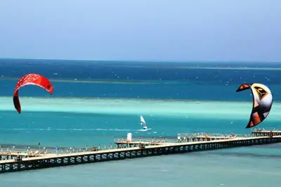 a beach with two kites flying over the water at Casablanca resort in Hurghada