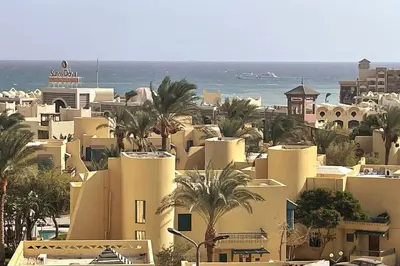 a group of buildings with palm trees and the ocean at Florenza Khamsin - sea view / free Wi-Fi in Hurghada