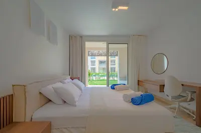 a bedroom with two beds and a desk and a mirror at Ollystays Mangroovy Seaview 3BR Beach and Pool Free access in Hurghada