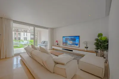 a living room with a couch and a flat screen tv at Ollystays Mangroovy Seaview 3BR Beach and Pool Free access in Hurghada