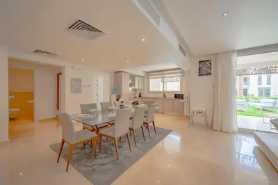 a dining room and kitchen with a table and chairs at Ollystays Mangroovy Seaview 3BR Beach and Pool Free access in Hurghada