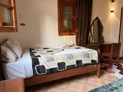 a bedroom with a bed with a quilt on it at Luxor Villa Hatshepsut in Luxor