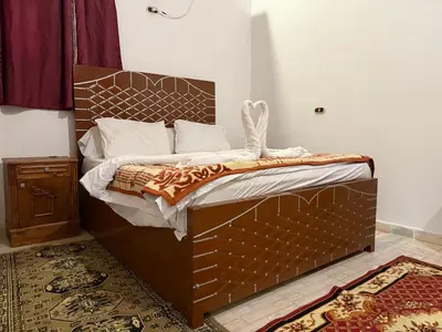 a bedroom with a large bed with a wooden headboard at Luxor Villa Hatshepsut in Luxor