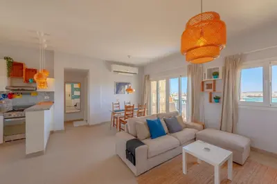 a living room with a couch and a table at Sunny 2 Bedroom + Private Roof Terrace Lagoon View in Hurghada