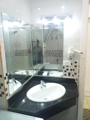 a man taking a picture of a bathroom with a sink at sheraton 212 in Hurghada