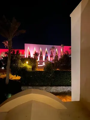 a night view of a building with pink lights at Lovely two bedroom apartment in Hurghada