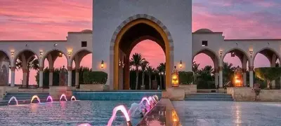 two pictures of a building with a pool with a fountain at VIVA Andalouse luxury family suite, private beach & pool, NO ORFI in Hurghada