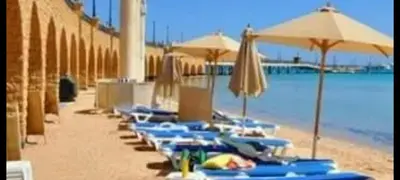 a row of blue chairs and umbrellas on a beach at VIVA Andalouse luxury family suite, private beach & pool, NO ORFI in Hurghada